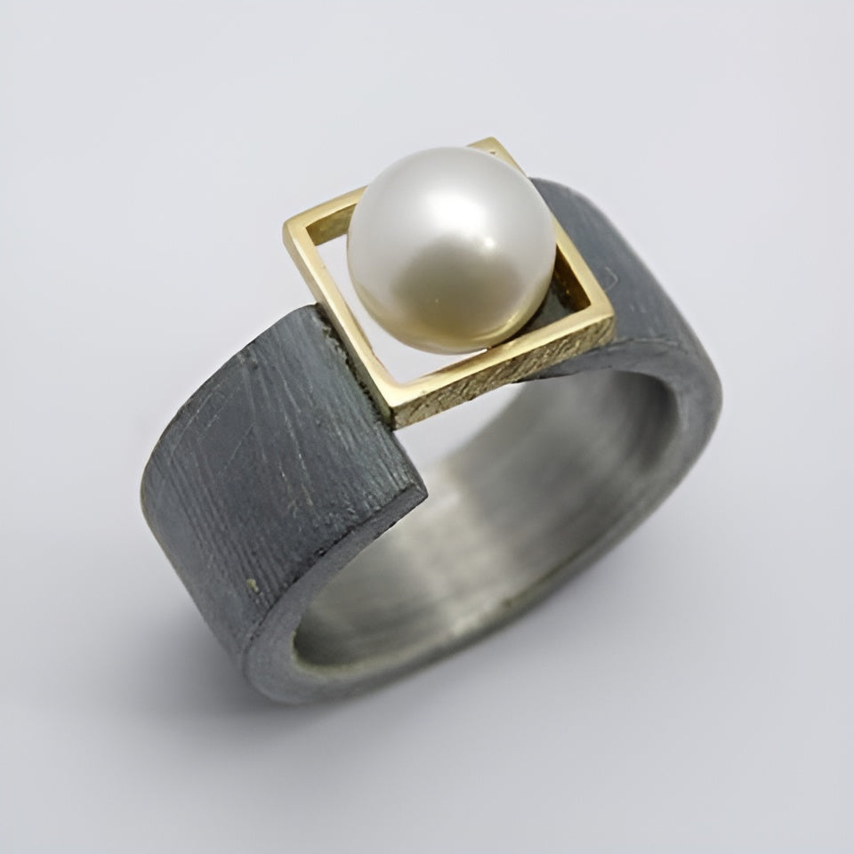 "Vintage-ring med mørk perle" can be rewritten as "Klassisk vintage ring med dyb perle".